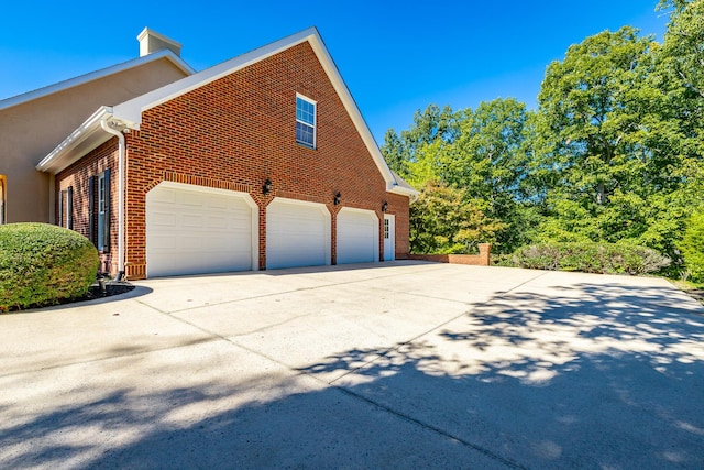 view of property exterior featuring brick siding and concrete driveway