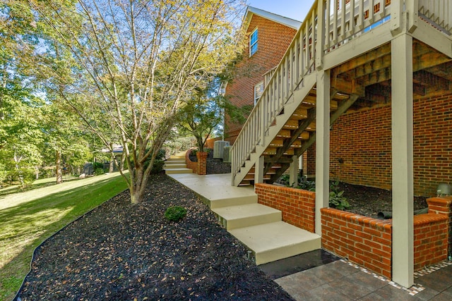 view of side of home featuring stairway and brick siding