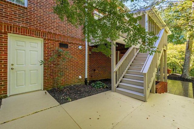 doorway to property with brick siding and a patio area