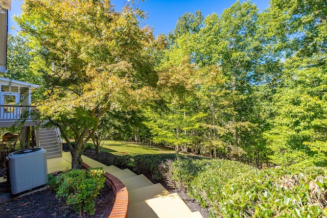 view of yard featuring central AC and stairs