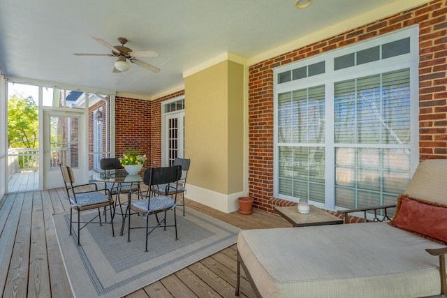 sunroom featuring a ceiling fan and outdoor dining space