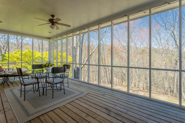sunroom / solarium featuring a ceiling fan and outdoor dining space