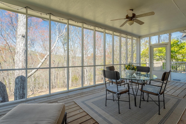 sunroom with ceiling fan and outdoor dining area