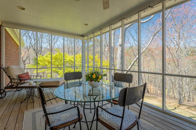 sunroom / solarium with ceiling fan and outdoor dining space
