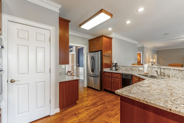 kitchen with light stone counters, a sink, dark wood-type flooring, freestanding refrigerator, and crown molding