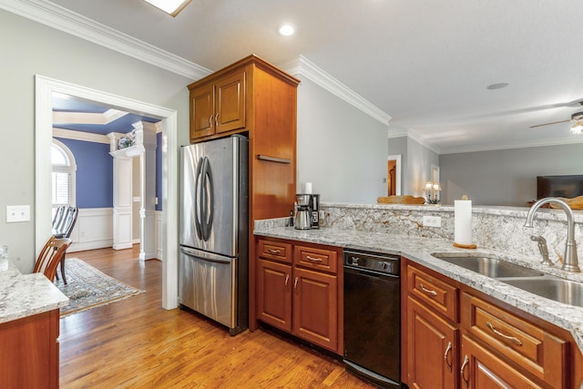 kitchen with ornamental molding, light wood-style flooring, a sink, and freestanding refrigerator