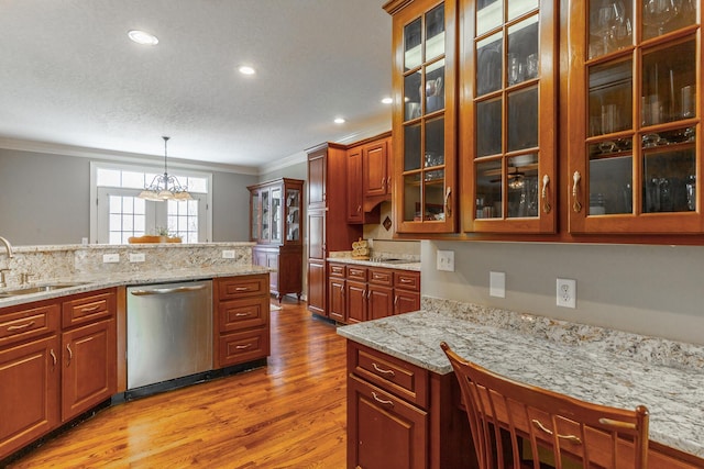 kitchen featuring light wood finished floors, a sink, crown molding, dishwasher, and decorative light fixtures