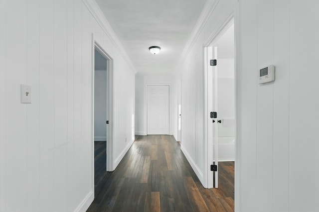 hallway with crown molding, baseboards, and dark wood finished floors
