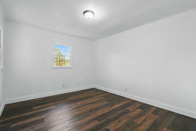 unfurnished room with dark wood finished floors, crown molding, and baseboards