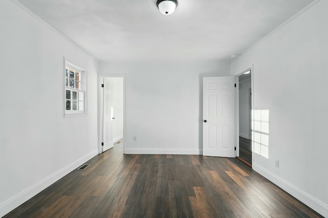 empty room with crown molding, plenty of natural light, baseboards, and dark wood-style flooring