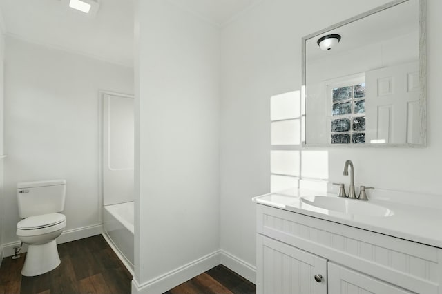 full bathroom featuring a washtub, toilet, wood finished floors, and baseboards