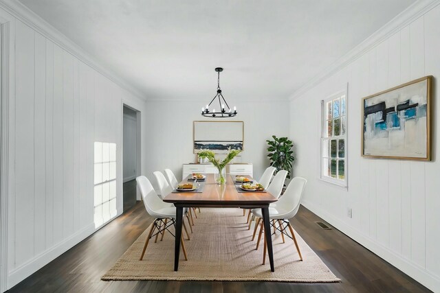 dining space with baseboards, a notable chandelier, ornamental molding, and dark wood finished floors