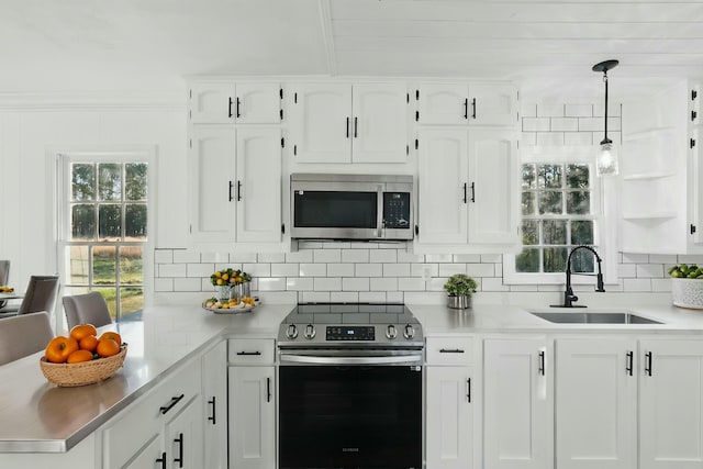 kitchen featuring light countertops, a sink, tasteful backsplash, appliances with stainless steel finishes, and white cabinetry