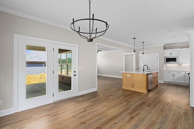 11819 Herons Haven Dr # 102, Soddy Daisy, TN 37379 - kitchen featuring appliances with stainless steel finishes, a chandelier, crown molding, wood finished floors, and an island with sink
