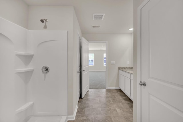 full bath featuring baseboards, visible vents, a shower, and vanity