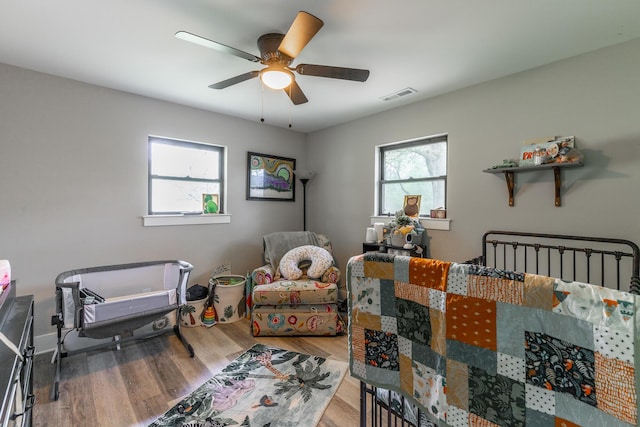 bedroom featuring visible vents, ceiling fan, and wood finished floors
