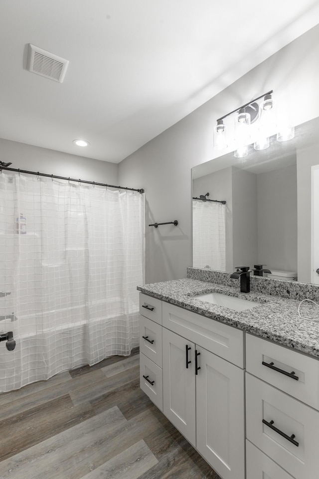 full bathroom featuring visible vents, curtained shower, recessed lighting, vanity, and wood finished floors