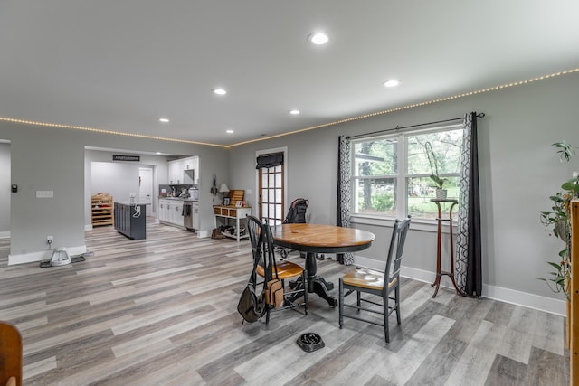 dining room featuring baseboards, light wood finished floors, and recessed lighting