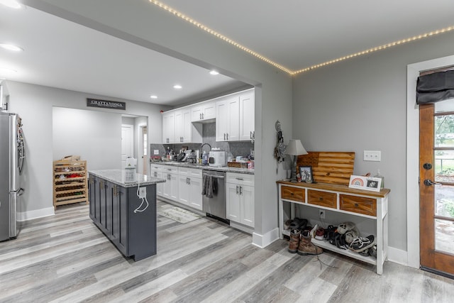 kitchen with light wood-style flooring, appliances with stainless steel finishes, white cabinets, and recessed lighting