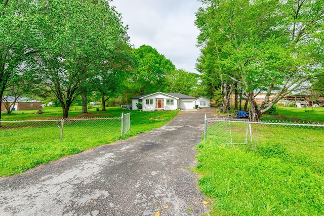 bungalow with driveway, a front lawn, and a fenced front yard