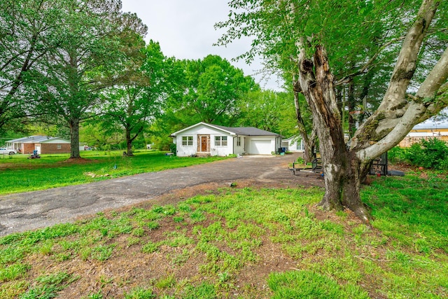 bungalow-style house featuring driveway, a front yard, and a garage