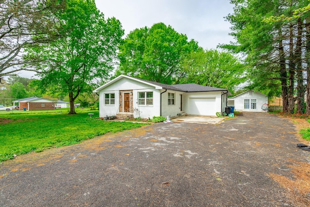 view of front of home with a garage, a front yard, and driveway