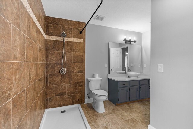204 Lake Haven Dr, Soddy Daisy, TN 37379 - bathroom featuring tiled shower, toilet, vanity, and baseboards