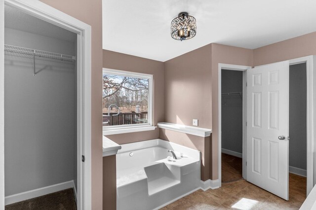 204 Lake Haven Dr, Soddy Daisy, TN 37379 - bathroom with a walk in closet, a garden tub, and baseboards