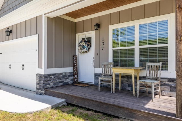 137 Elm Ave, Ringgold, GA 30736 - property entrance featuring board and batten siding, a porch, stone siding, and a garage