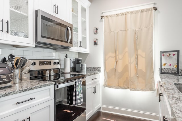 137 Elm Ave, Ringgold, GA 30736 - kitchen with white cabinetry, light stone countertops, backsplash, appliances with stainless steel finishes, and dark wood-style floors