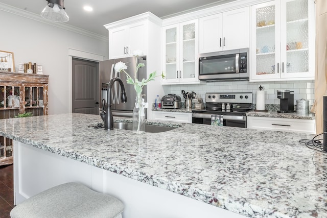 137 Elm Ave, Ringgold, GA 30736 - kitchen with tasteful backsplash, crown molding, white cabinets, light stone countertops, and appliances with stainless steel finishes