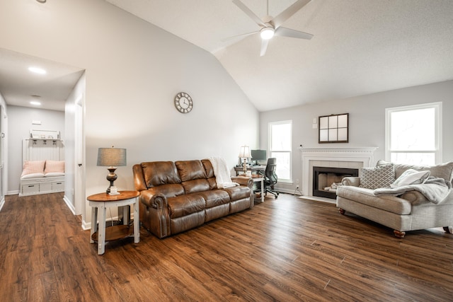 living area with dark wood-style flooring, high vaulted ceiling, baseboards, ceiling fan, and a tiled fireplace