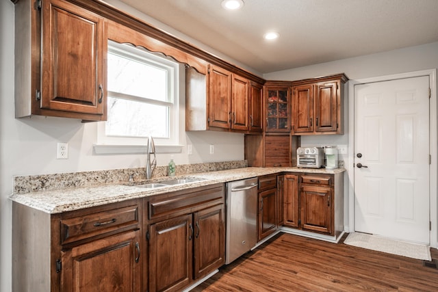 kitchen featuring a sink, light stone countertops, dark wood-type flooring, stainless steel dishwasher, and recessed lighting