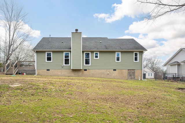 rear view of property with a lawn, a chimney, a shingled roof, and a deck