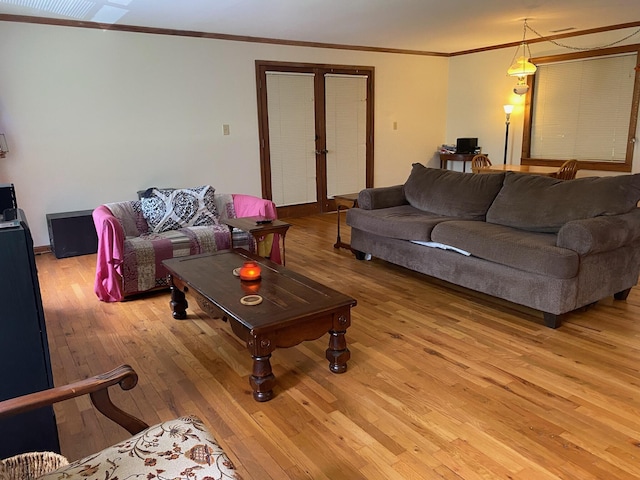 living room with french doors, visible vents, crown molding, baseboards, and light wood-style flooring