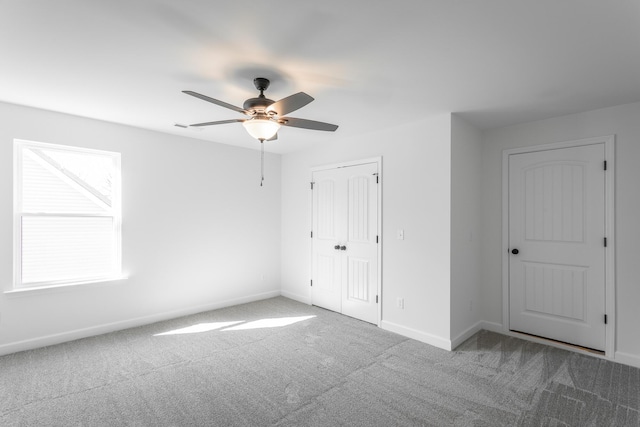 unfurnished bedroom featuring a closet, carpet flooring, baseboards, and ceiling fan