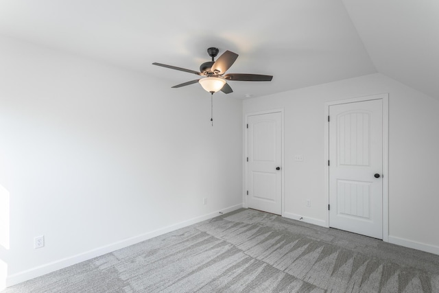 unfurnished bedroom featuring baseboards, a ceiling fan, vaulted ceiling, and carpet