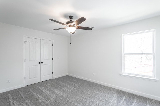 unfurnished bedroom featuring baseboards, a closet, multiple windows, and carpet