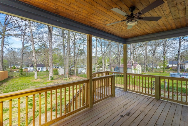 unfurnished sunroom with a residential view and a ceiling fan