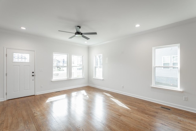 foyer featuring visible vents, ornamental molding, baseboards, and ceiling fan