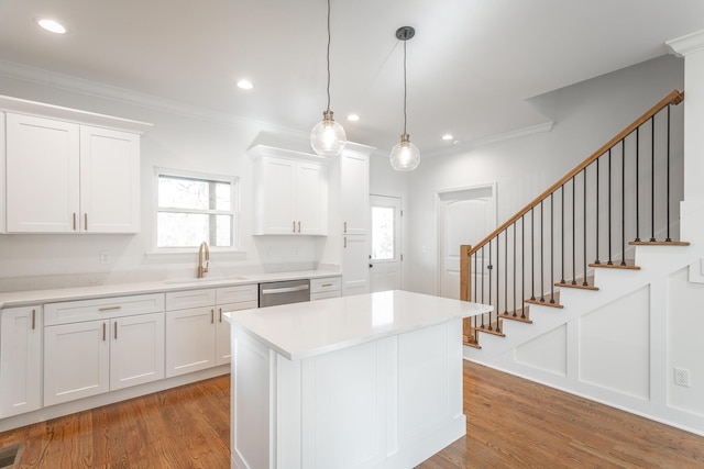 kitchen featuring dishwasher, light wood finished floors, white cabinetry, and a sink