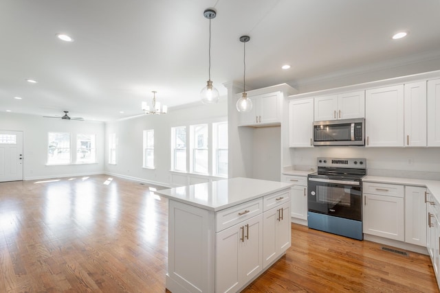 kitchen featuring ceiling fan with notable chandelier, stainless steel appliances, light countertops, white cabinetry, and recessed lighting