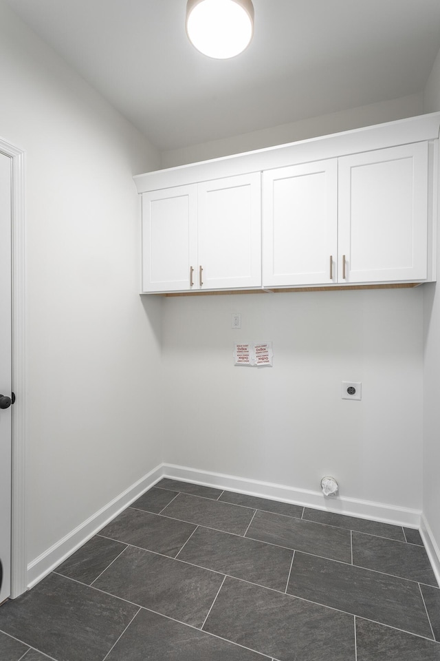laundry room with baseboards, hookup for an electric dryer, and cabinet space