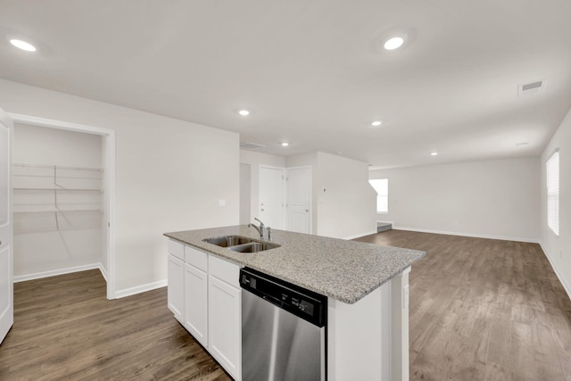 kitchen featuring stainless steel dishwasher, a center island with sink, a sink, visible vents, and white cabinets