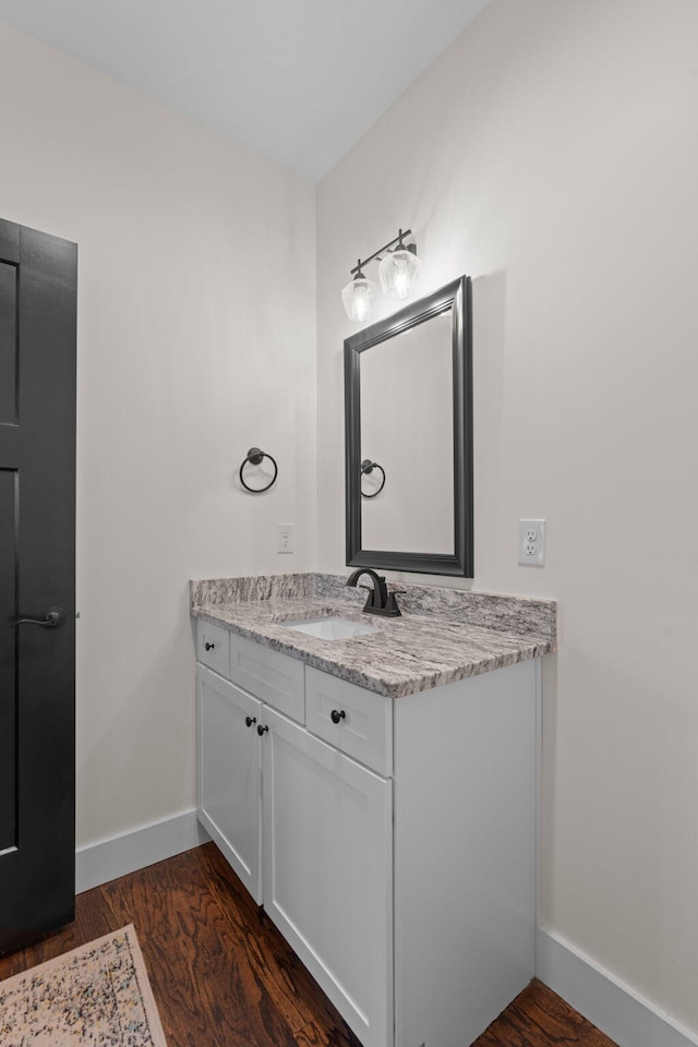 bathroom with baseboards, wood finished floors, and vanity