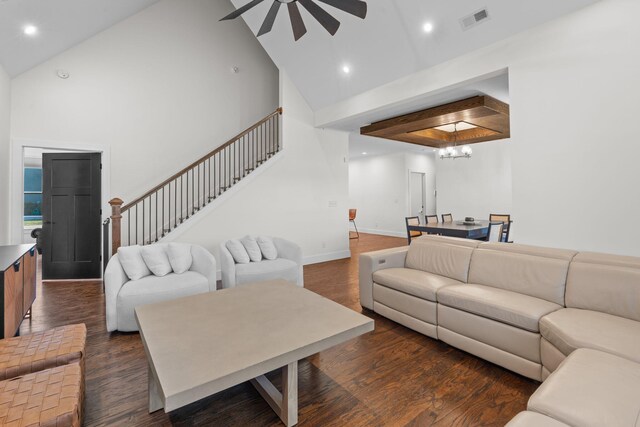 living room with stairway, dark wood-type flooring, baseboards, visible vents, and a ceiling fan