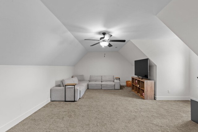 living area featuring baseboards, vaulted ceiling, carpet, and a ceiling fan