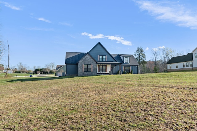 view of front of home with a front yard and stone siding
