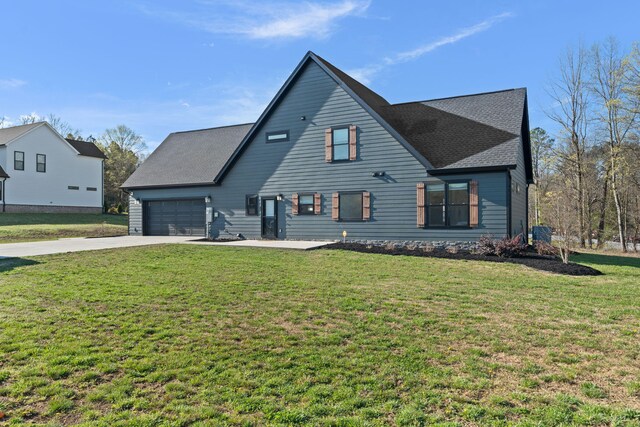 rear view of house with a lawn, a garage, and concrete driveway