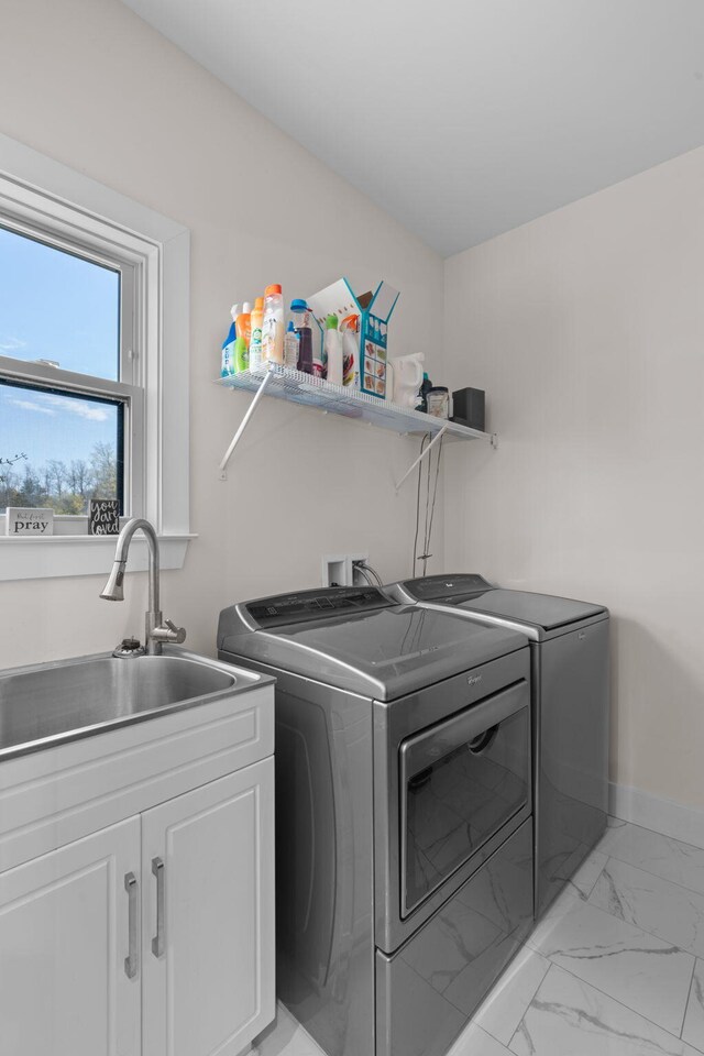 washroom featuring washer and clothes dryer, a sink, marble finish floor, baseboards, and cabinet space